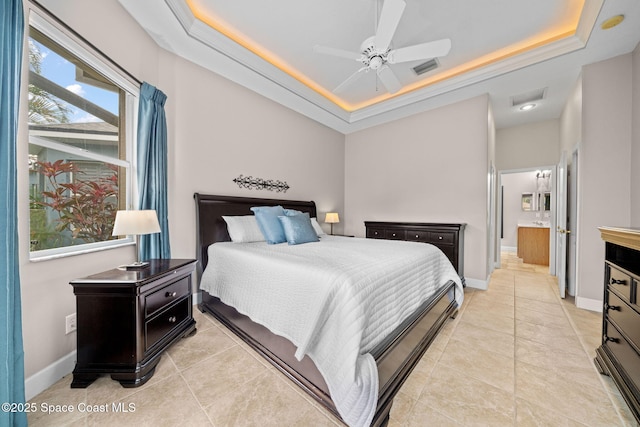 bedroom featuring a tray ceiling, light tile patterned flooring, and baseboards