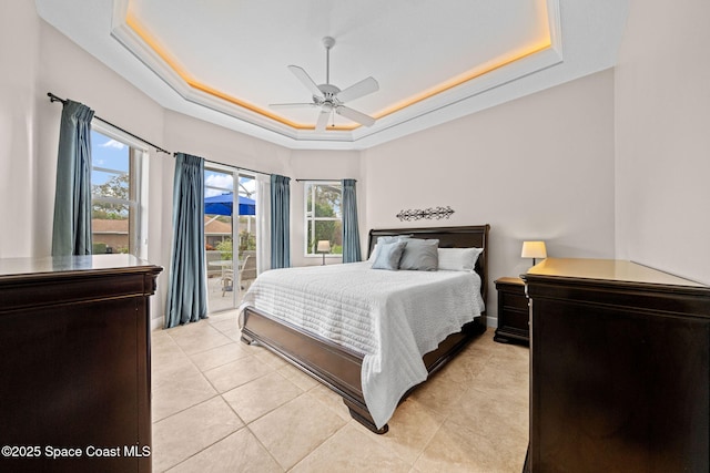 bedroom featuring light tile patterned floors, a tray ceiling, a ceiling fan, and access to exterior