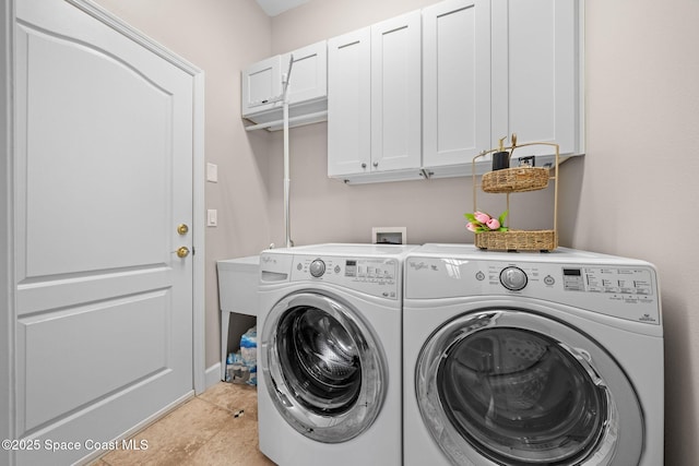 washroom featuring cabinet space, washing machine and dryer, and light tile patterned floors