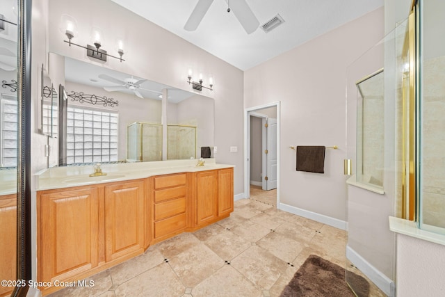 full bathroom featuring double vanity, visible vents, a sink, a shower stall, and ceiling fan