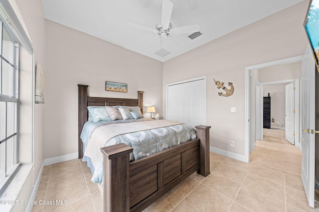 bedroom with a closet, visible vents, a ceiling fan, light tile patterned flooring, and baseboards