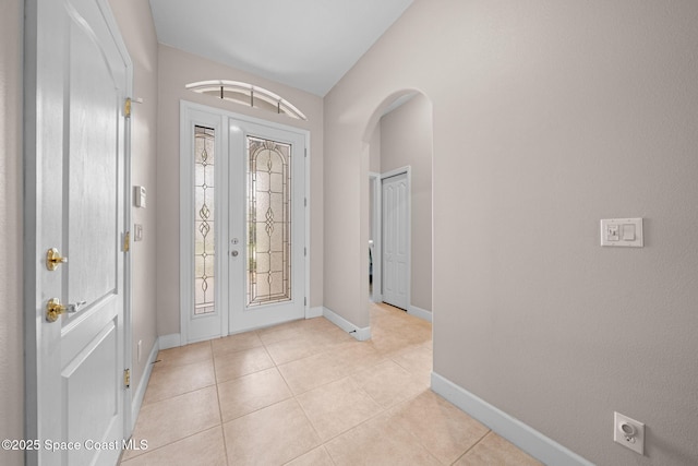 entrance foyer featuring a healthy amount of sunlight, baseboards, and light tile patterned floors