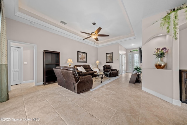 living room featuring visible vents, baseboards, a raised ceiling, and light tile patterned flooring