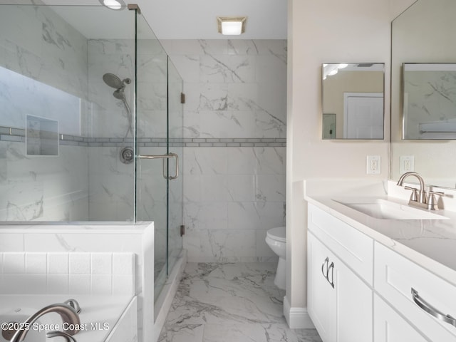 full bathroom featuring toilet, a washtub, vanity, marble finish floor, and a marble finish shower