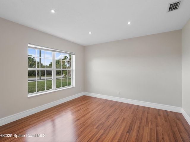 unfurnished room featuring recessed lighting, visible vents, baseboards, and wood finished floors