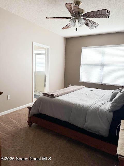 bedroom with a ceiling fan, a textured ceiling, ensuite bath, carpet floors, and baseboards