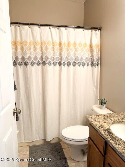 full bathroom featuring vanity, tile patterned floors, curtained shower, and toilet