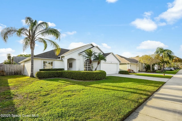 view of front of property with driveway, an attached garage, fence, and a front yard