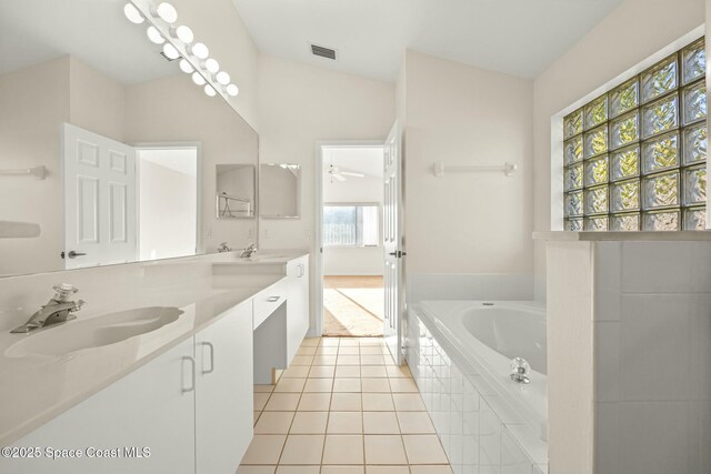 bathroom with tile patterned flooring, visible vents, a sink, and a garden tub