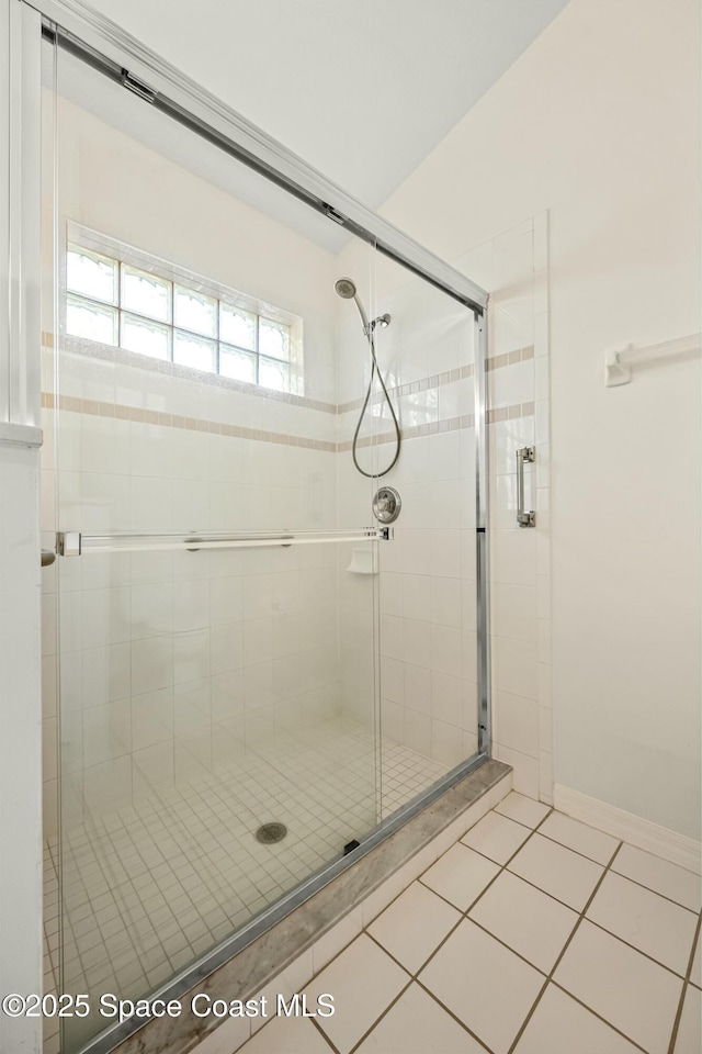 full bathroom with tile patterned flooring, a shower stall, and baseboards