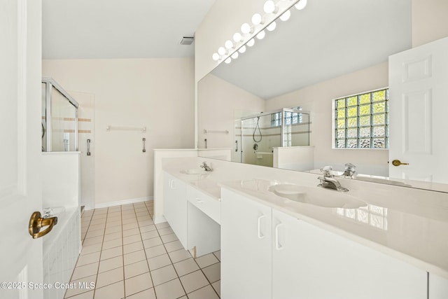 bathroom with a stall shower, a garden tub, a sink, and tile patterned floors