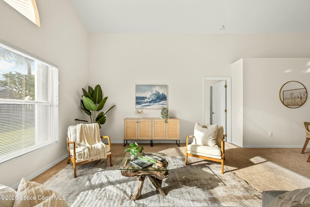 living area featuring light colored carpet and baseboards