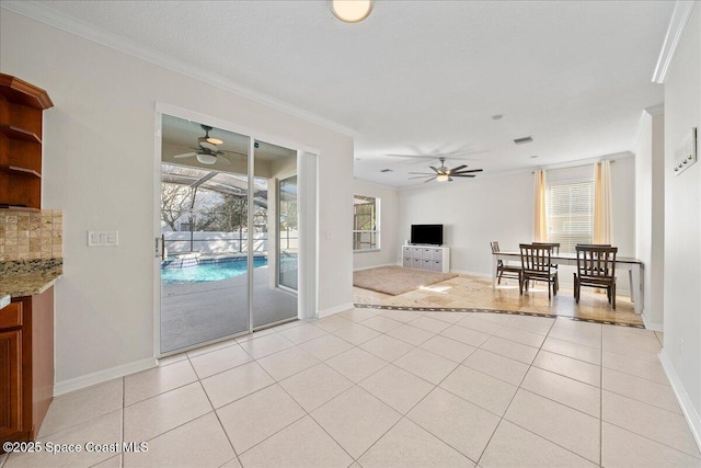 unfurnished living room with light tile patterned floors, ceiling fan, ornamental molding, and visible vents