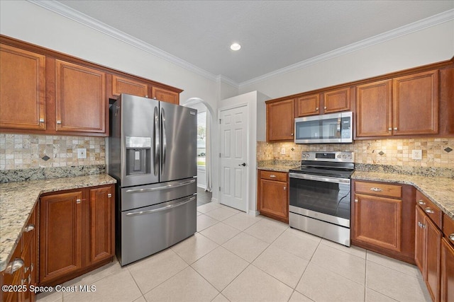 kitchen with light tile patterned floors, appliances with stainless steel finishes, and light stone counters