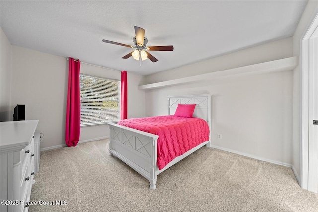 bedroom with a ceiling fan, light carpet, a textured ceiling, and baseboards