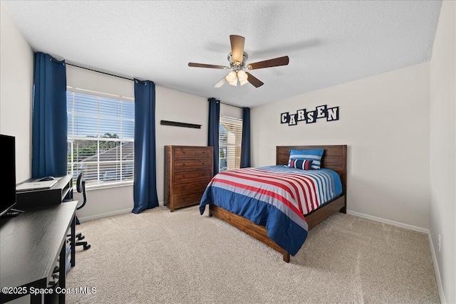 bedroom with a ceiling fan, light colored carpet, a textured ceiling, and baseboards