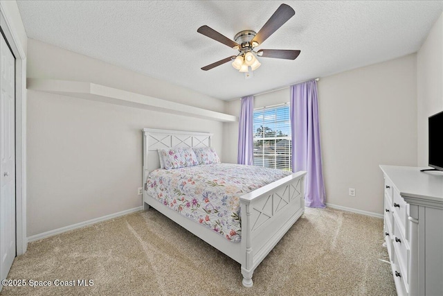 bedroom featuring a ceiling fan, light carpet, a textured ceiling, and baseboards