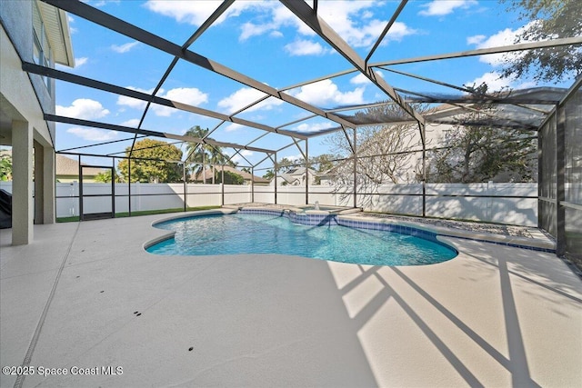 view of pool with glass enclosure, a patio, a fenced backyard, and a pool with connected hot tub