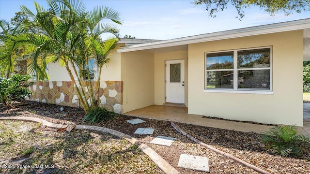 view of exterior entry with stucco siding