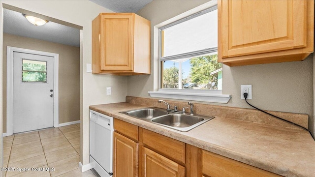 kitchen featuring dishwasher, light brown cabinetry, a sink, and a healthy amount of sunlight