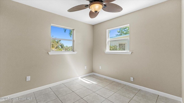 spare room with light tile patterned floors, baseboards, and a ceiling fan