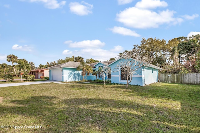 ranch-style home featuring a garage, fence, driveway, stucco siding, and a front lawn