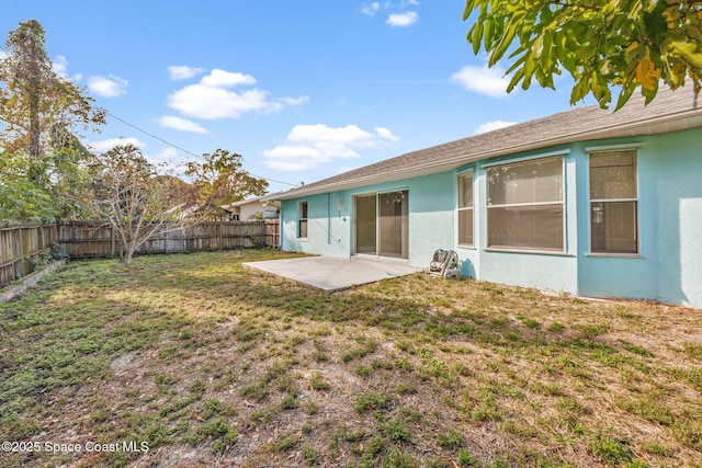 rear view of property with a patio area, a fenced backyard, a lawn, and stucco siding