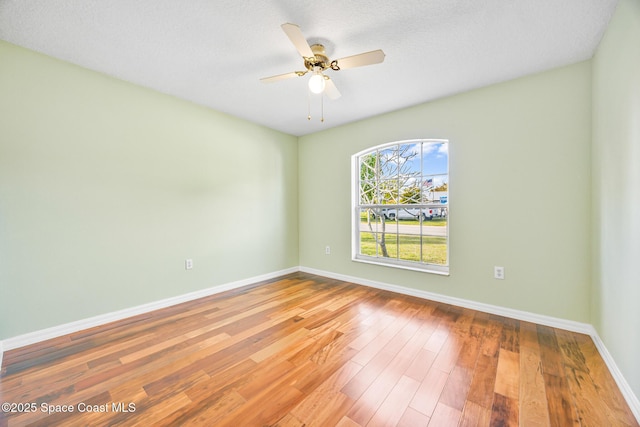 unfurnished room featuring ceiling fan, a textured ceiling, wood finished floors, and baseboards