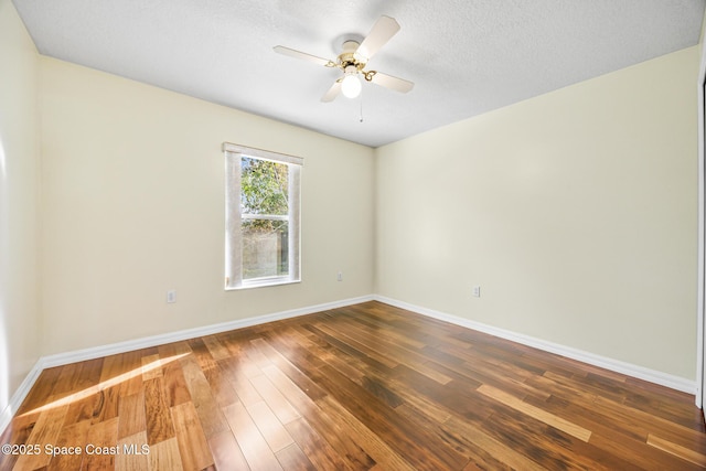 spare room with a ceiling fan, a textured ceiling, baseboards, and wood finished floors