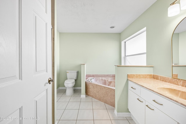 bathroom with tile patterned floors, toilet, vanity, baseboards, and a bath