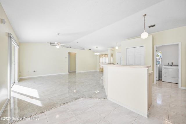 kitchen with lofted ceiling, ceiling fan with notable chandelier, visible vents, hanging light fixtures, and washer / dryer