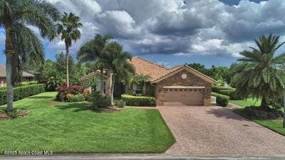 view of front facade with a garage, a front lawn, and decorative driveway