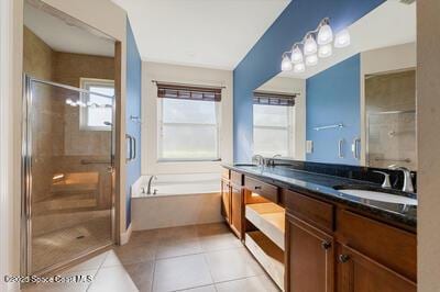 full bath with a sink, a bath, tile patterned floors, double vanity, and a stall shower