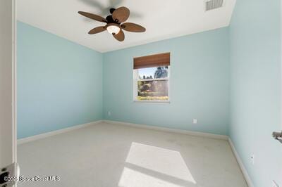 empty room with baseboards, visible vents, and a ceiling fan