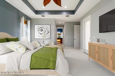 bedroom featuring a tray ceiling, light carpet, recessed lighting, and multiple windows