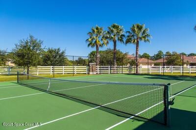 view of tennis court with community basketball court and fence