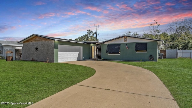 view of front of house with a garage, fence, a front lawn, and concrete driveway