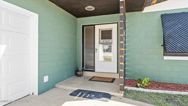 entrance to property featuring concrete block siding