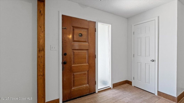 foyer featuring light wood-type flooring and baseboards