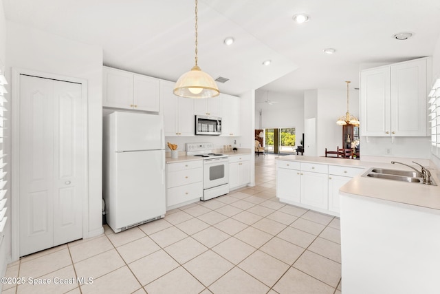 kitchen featuring white appliances, visible vents, decorative light fixtures, a peninsula, and a sink