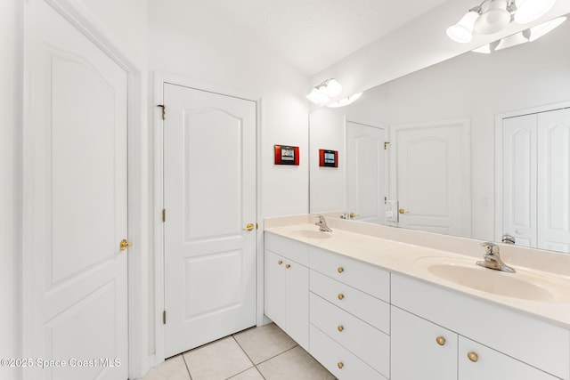 bathroom with double vanity, tile patterned flooring, and a sink