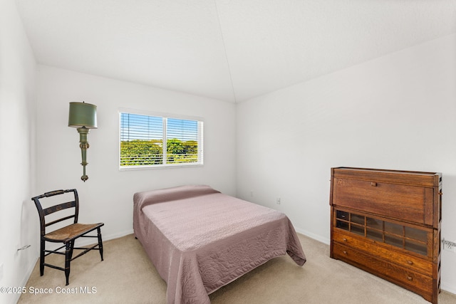 bedroom featuring light carpet and baseboards