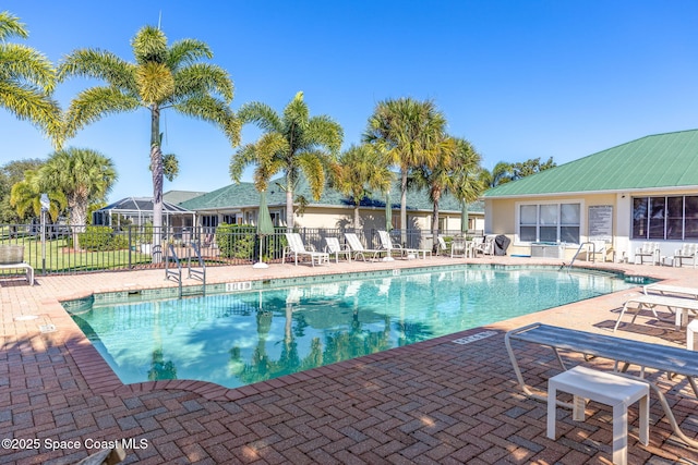 pool with a patio area and fence