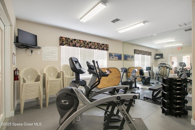 gym featuring visible vents and a textured ceiling