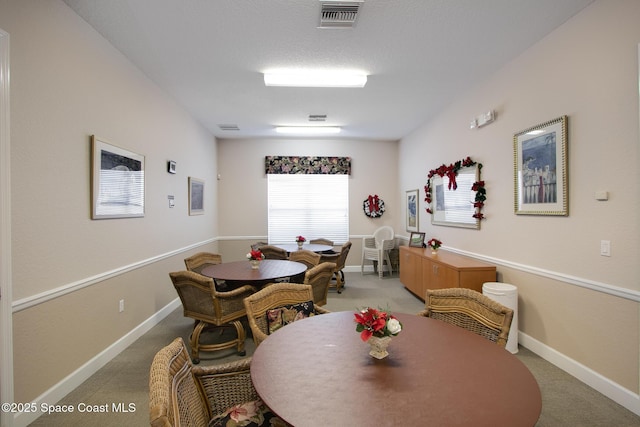 dining room with visible vents, light carpet, and baseboards