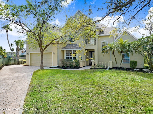 view of front of home featuring a front lawn, decorative driveway, and stucco siding