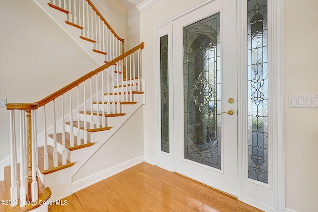 entrance foyer featuring stairway, baseboards, and wood finished floors