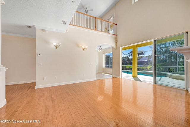 unfurnished living room featuring wood-type flooring, visible vents, ceiling fan, and baseboards