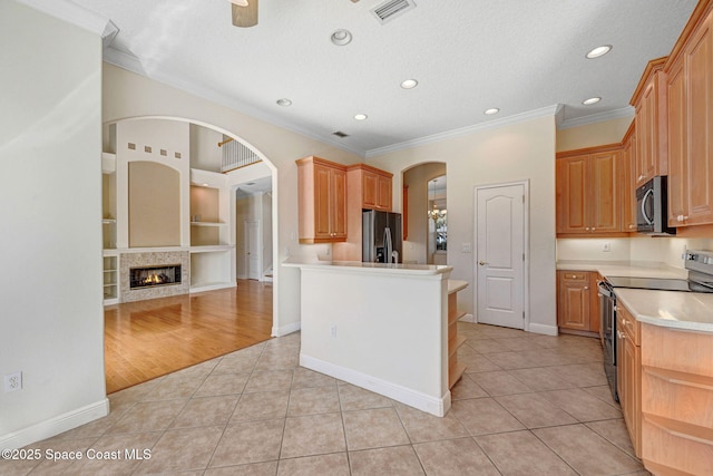 kitchen featuring built in features, appliances with stainless steel finishes, open floor plan, light countertops, and light tile patterned flooring