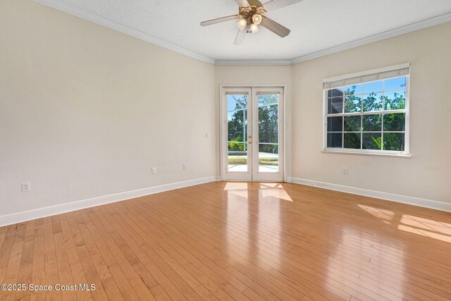 unfurnished room featuring french doors, light wood finished floors, ornamental molding, a ceiling fan, and baseboards